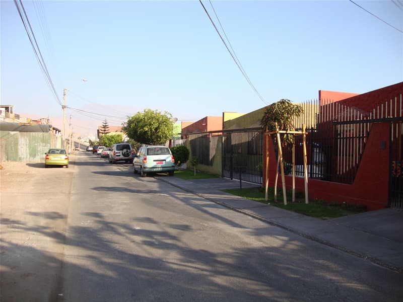 Vista de calle del proyecto Pasaje San Sebastián, casas coloridas y barrio residencial tranquilo